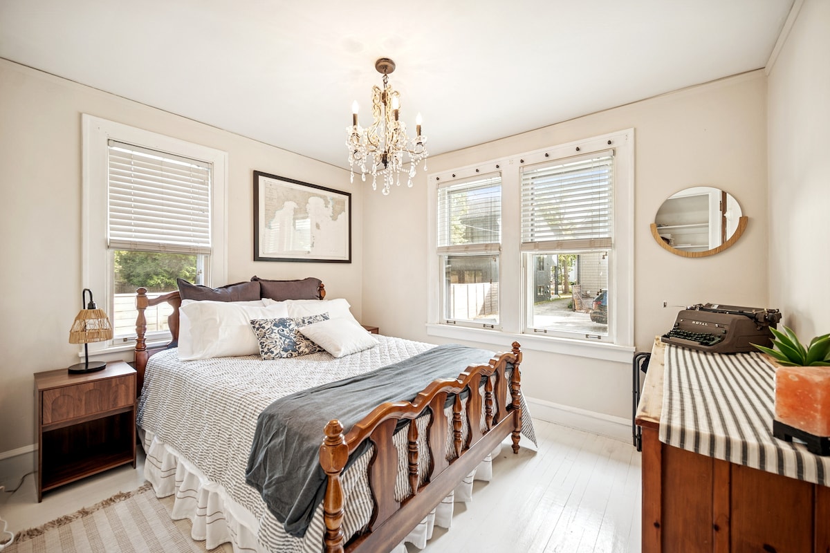 Primary bedroom with queen bed, dresser, and lots of natural light