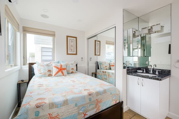 This bedroom is on the first floor with an attached bath. It has a double bed, cable TV, bathroom vanity, and closet.