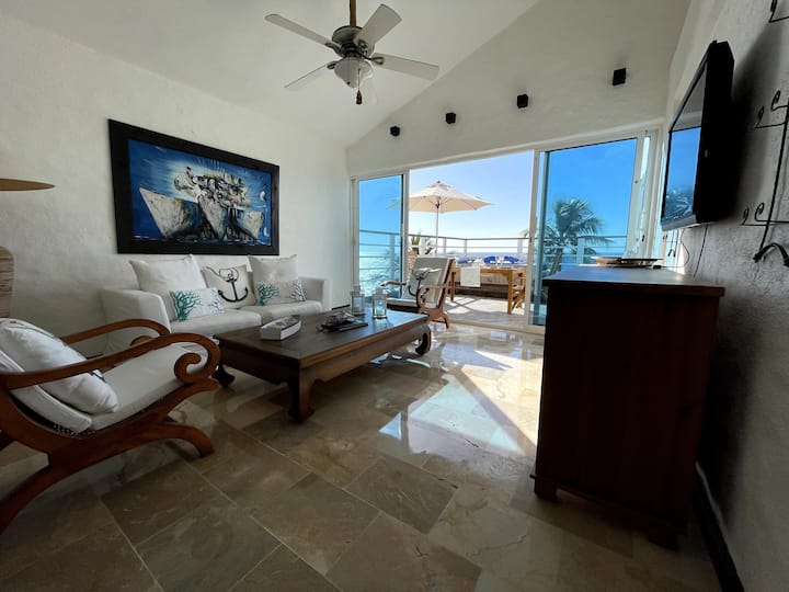 Area salotto al piano superiore con televisore e accesso al patio e alla vasca idromassaggio