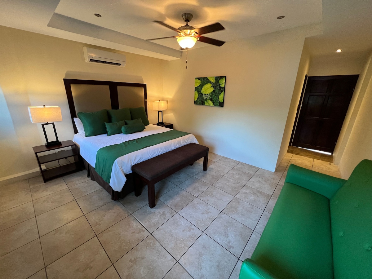 Room with king bed and sofa.