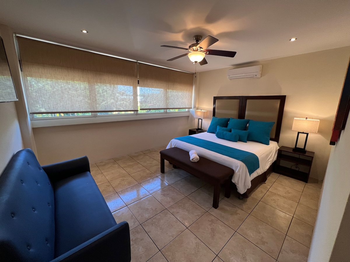 Bedroom with king bed and sofa. 