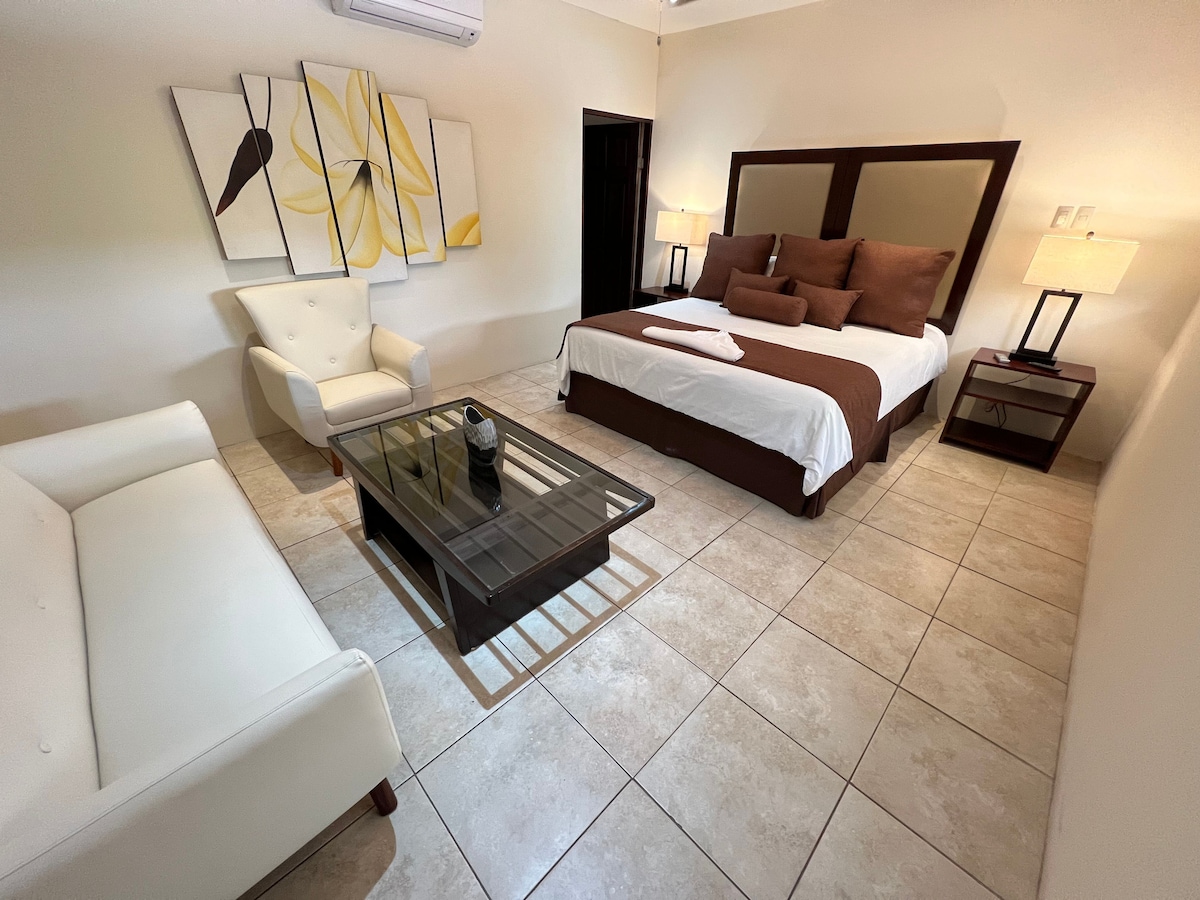 Bedroom with king bed and sofa. 