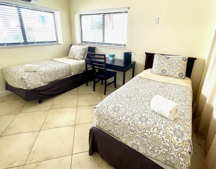 第三间卧室配有两张单人床、电脑桌和高清电视。