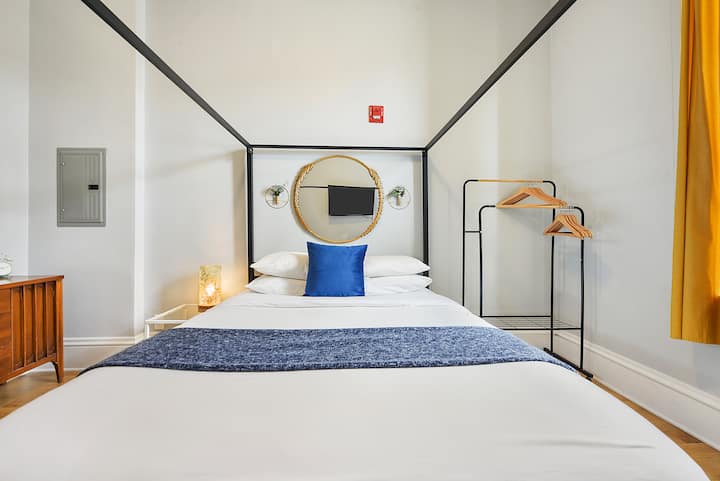 舒适的标准双人床，配有独特的床架和电视，适合悠闲的电影之夜。