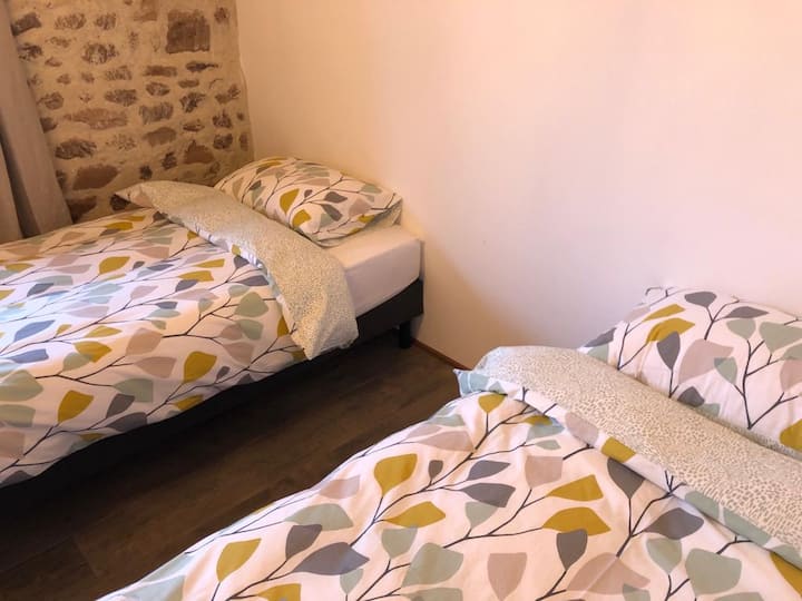 Dormitorio con dos camas individuales con entresuelo y vistas orientales de gran alcance sobre el campo circundante.