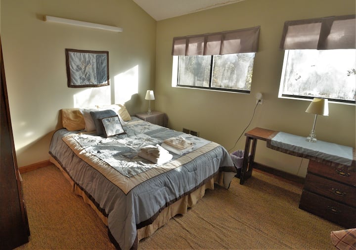 Bedroom 4 has a queen size bed and two bunk beds in a sunny setting with a great view of the valley below. 