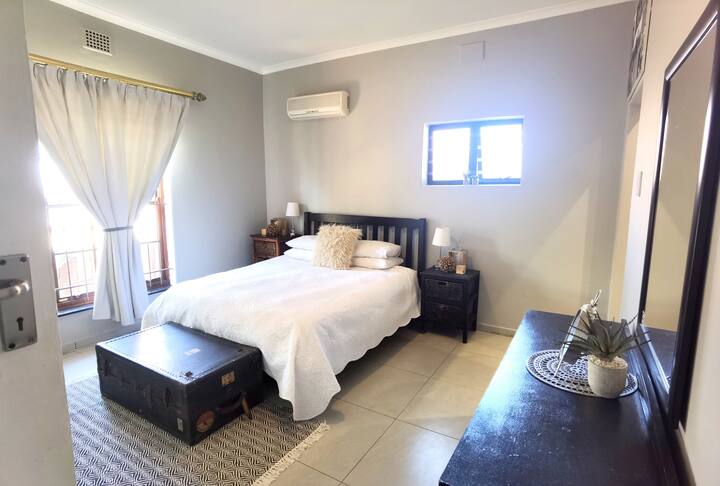 غرفة نوم رئيسية مع حمام داخلي ومكيف هواء