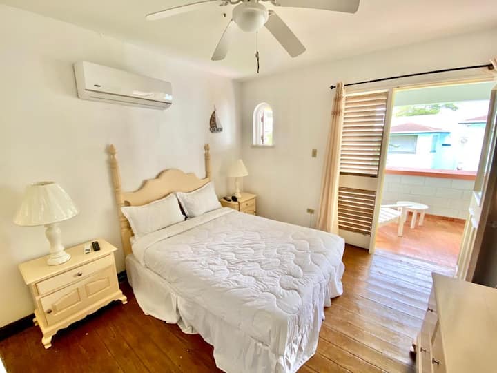Master bedroom with shared access to the ocean view patio. Fully equipped with a AC, Cable TV, Ceiling fan, phone, and en suite bathroom. 