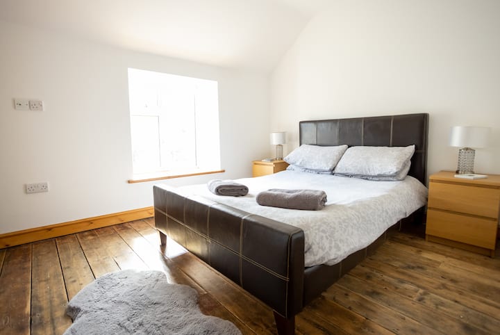 Krasna, svijetla spavaća soba s bračnim krevetom.