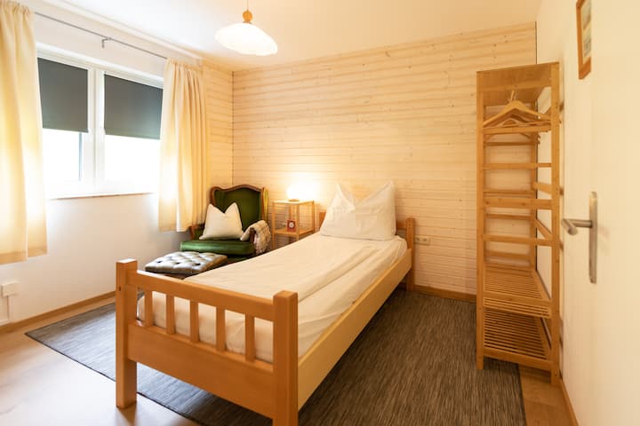 Საძინებელი ერთადგილიანი საწოლით და მყუდრო საკითხავი კუთხე