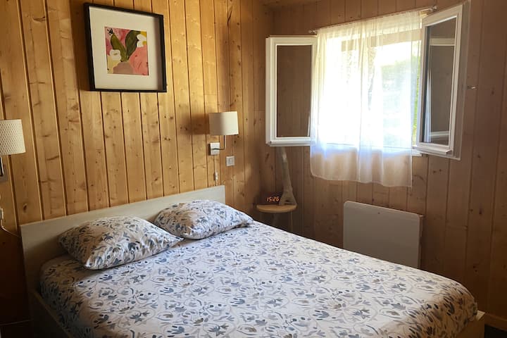 Дупли кревет во спална соба со прозорец на терасата.