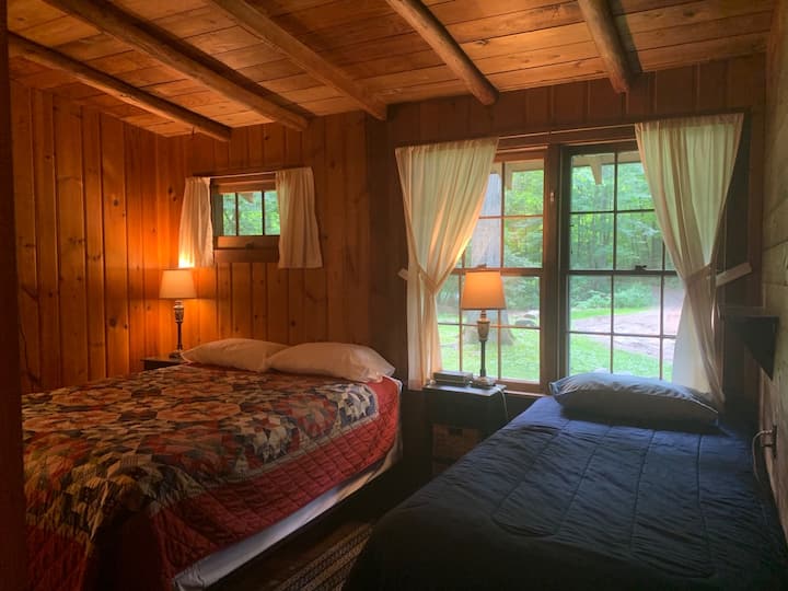 La chambre une dispose d'un lit double et de lits jumeaux avec tables de chevet, lampes de table et un banc.