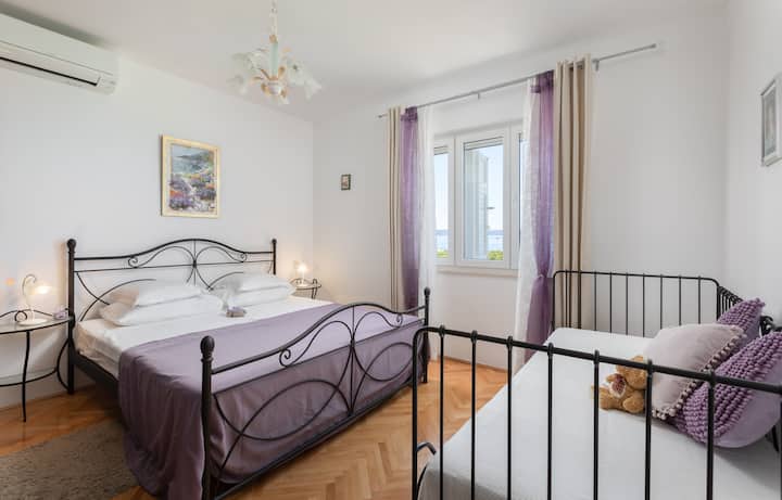 宽敞的卧室，配备三人衣橱，可欣赏海景和城市景观，并配备空调。