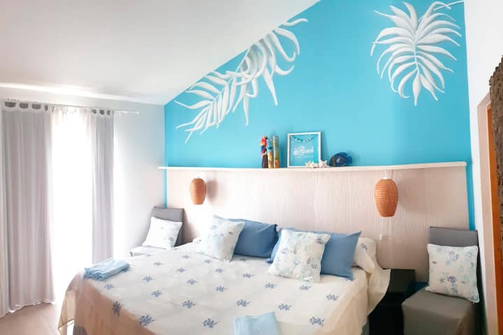 חדר ראשי עם מיטת קינג סייז 200X200 ס"מ. מהחלון אפשר לראות את הים הקריבי ואת הפארק הטבעי.