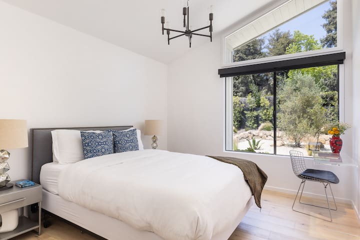 Dormitorio con techos altos inclinados y tragaluz.  Nuevo colchón tamaño queen Néctar y sábanas cómodas. Espacio de trabajo dedicado.