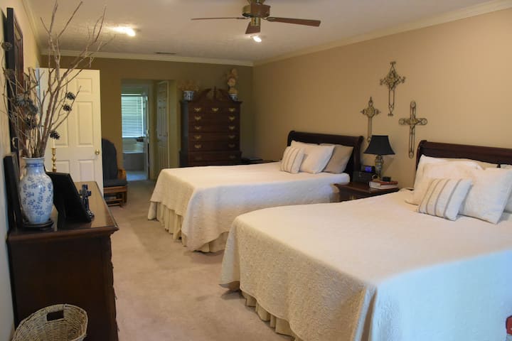 Large master bedroom on the first floor contains two queen sized beds, reading and desk area, storage and closet space.  Adjoining bathroom.