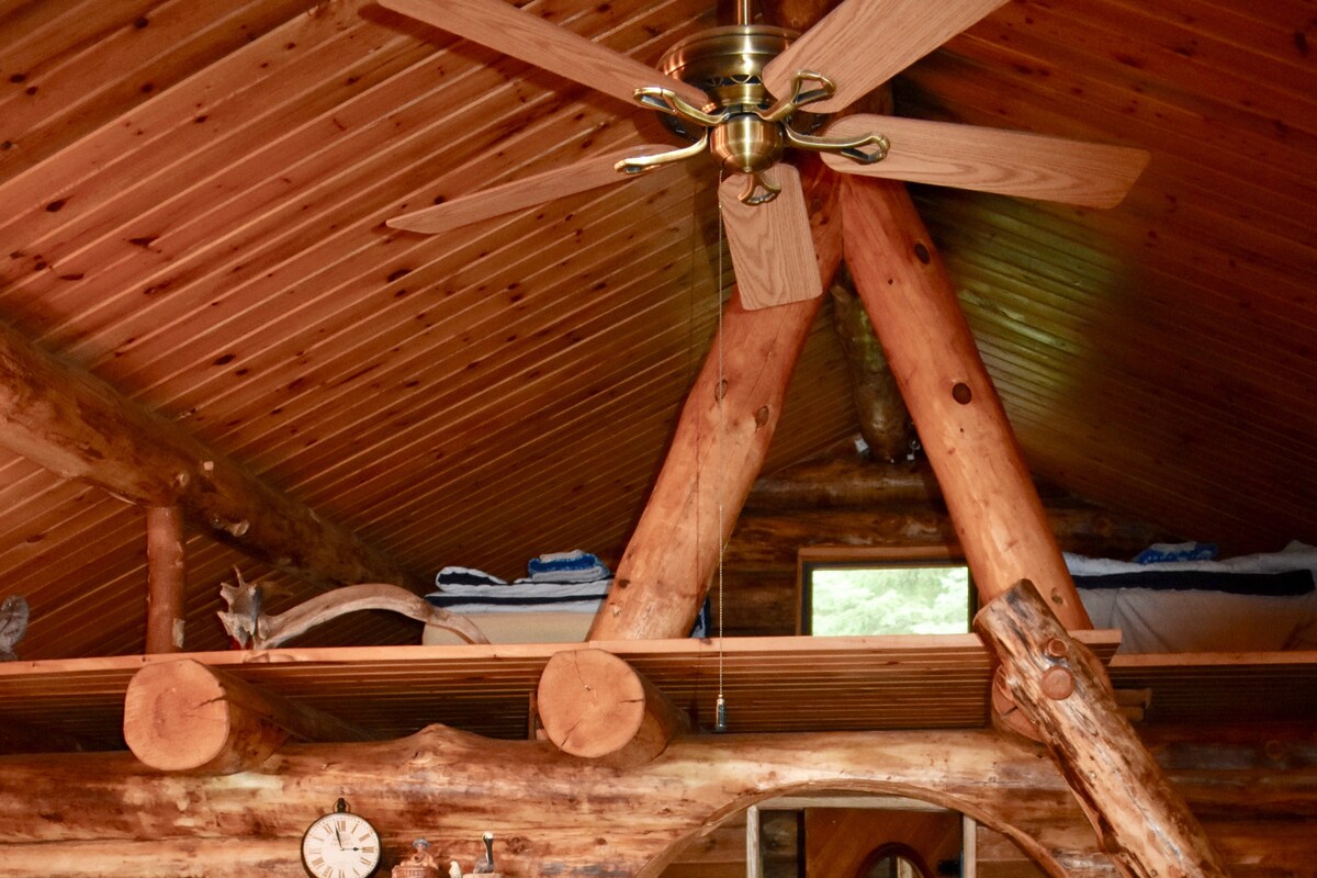 Espacio en loft en cabaña de madera: el área para dormir desbordada incluye una cama doble y cama doble.