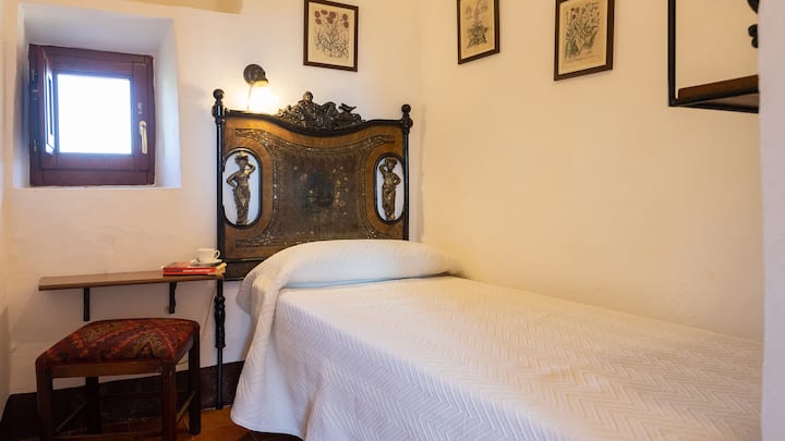 Habitación individual con carácter, muebles históricos y un ambiente tranquilo e íntimo.