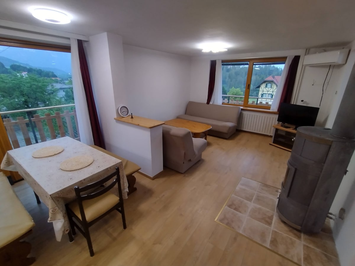 Jedáleň a obývacia izba s výhľadom na hory a jazero.