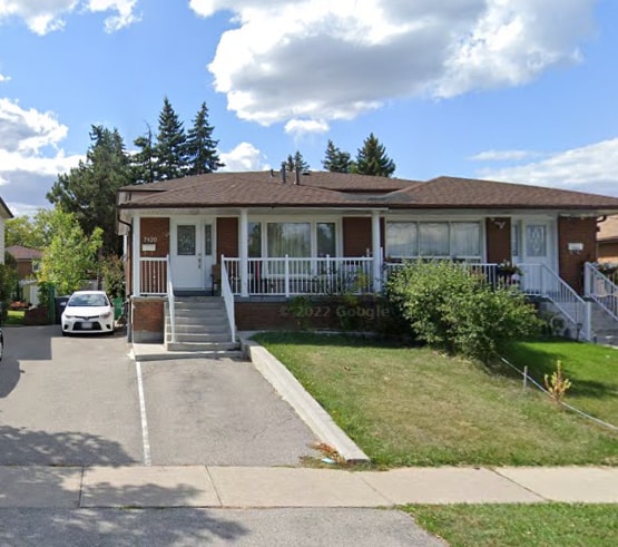 The exterior view of a spacious, newly renovated house is presented. A welcoming front porch with white railings is visible, along with large windows allowing natural light. A well-maintained lawn is featured, and two parking spots are available in the driveway, accommodating guest vehicles.