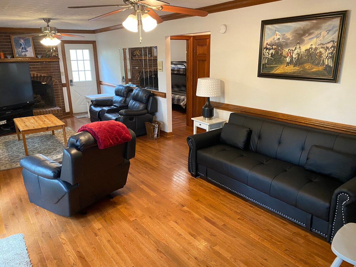 ห้องดูทีวีขนาด 73 "- โซฟาอยู่เบื้องหน้าแปลงเป็นเตียงเต็มรูปแบบเอียงด้านหลังลงเตาผิงใช้งานไม่ได้เนื่องจากความกังวลด้านความปลอดภัย