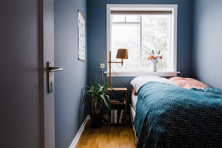 ห้องนอนเป็นห้องที่อบอุ่นมีเตียงควีนไซส์และหน้าต่างสวยๆหันหน้าไปทางทิศใต้ มีขาตั้งเตียงสไตล์สแกนดิเนเวียที่ทันสมัยและไฟอ่านหนังสือและการออกแบบไอซ์แลนด์บนผนัง 