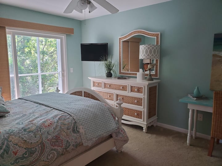 El dormitorio principal tiene una cama tamaño queen con bonitas sábanas y ropa de cama.  Hay un televisor inteligente con control remoto. También tienes acceso desde esta habitación al porche protegido. Es muy agradable escuchar los pájaros por la mañana desde el bosque detrás del porche.