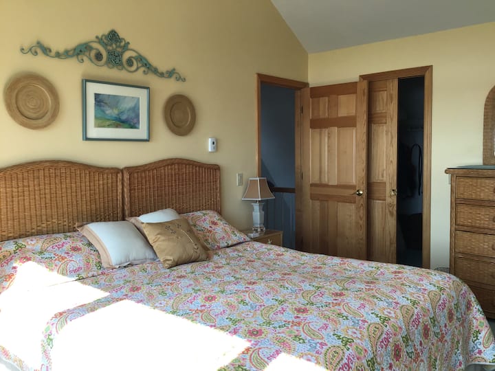 Dormitorio principal tamaño king en el segundo piso con baño adjunto con ducha a ras de suelo.