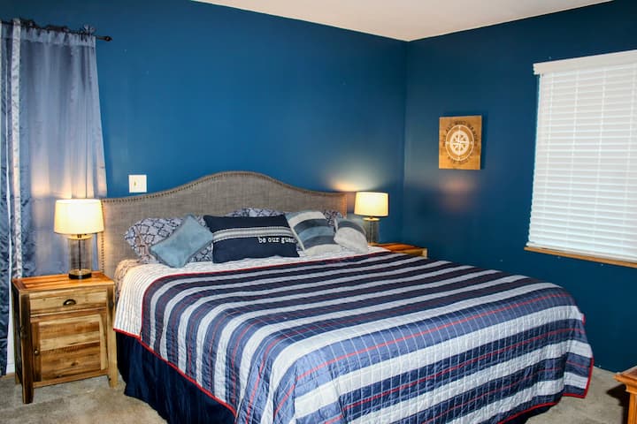 The Navy Blue Room- King Bed

Upstairs bedroom with dresser, chest, nightstands, and lamps.