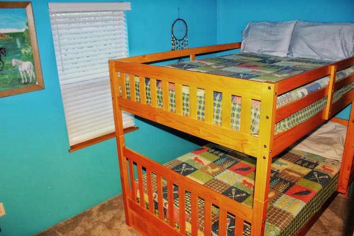 The Blue Room- Full-over-Full Bunkbed. Located in the downstairs hallway with a chest of drawers, nightstand, and lamp.