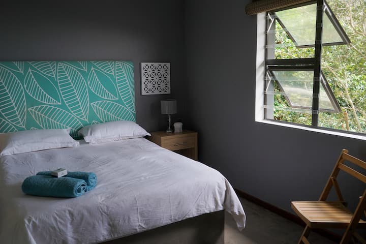 חדר שינה צמוד שני עם מיטת קווין סייז.