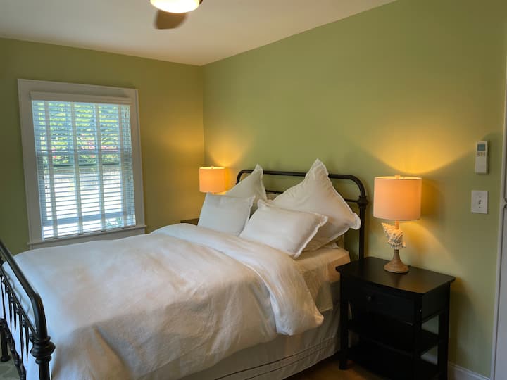 Chumba kikuu cha kulala chenye Kitanda aina ya Queen, kabati maradufu na matandiko ya kifahari.