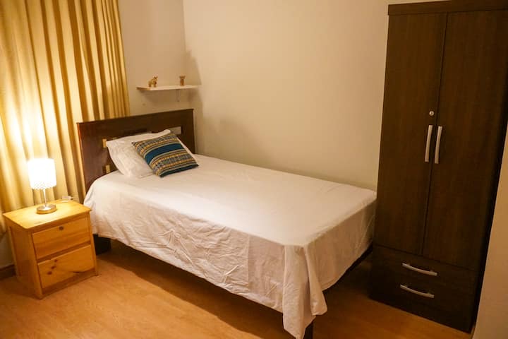 Dormitorio individual con armario y mesita de noche