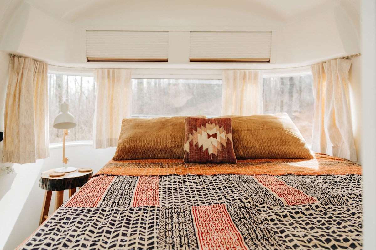 The queen bed situated at the back end of the Airstream has amazing morning views. 