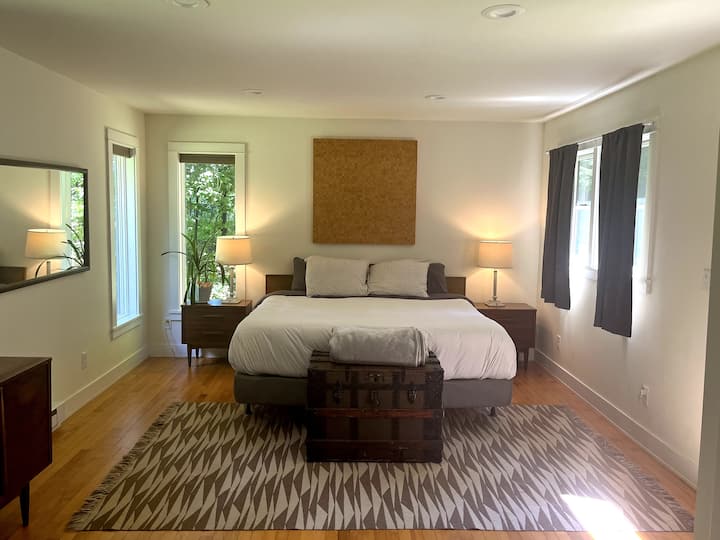 غرفة نوم رئيسية بسرير بحجم كبير يطل على الغابة 