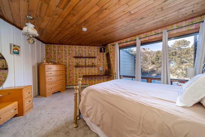 Second floor bedroom with queen bed.  Great view of Colorado National Monument and some seriously funky rose wall paper. 
