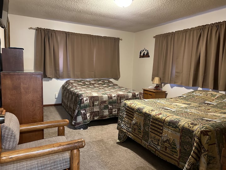 Upstairs bedroom with two Queen Beds, dresser, TV and large closet. 