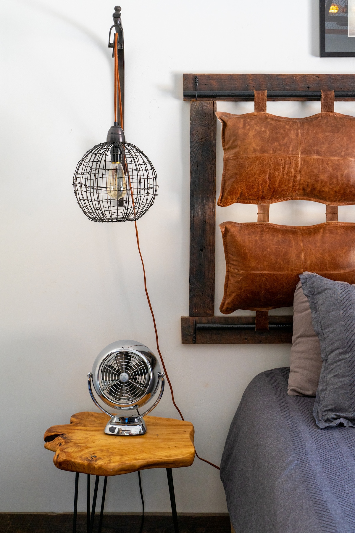 Custom Headboard with leather, wood and metal. Industrial sconce lighting, vintage/modern fan