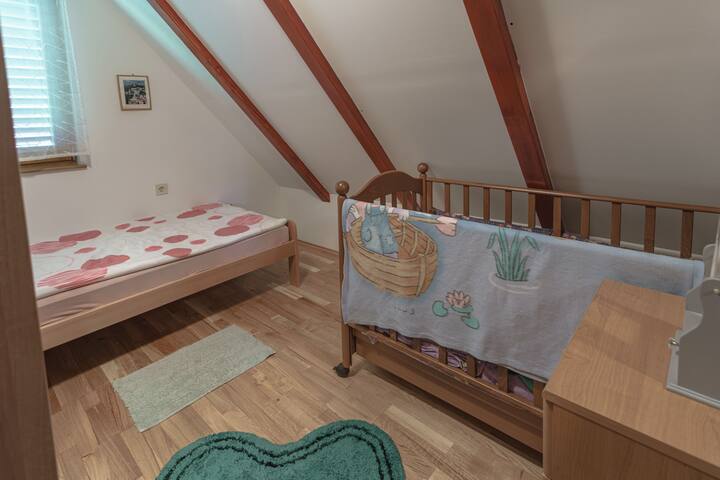 This is a bedroom that contains a baby cot.