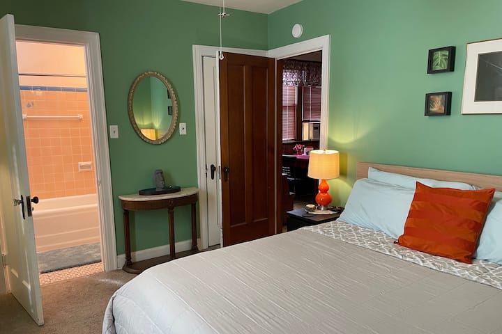 King size bed with four pillows, luxury sheets and bedding along with luxury towels and super fluffy blanket in the walk in closet behind the bedroom door. You can see the dining room through the door for reference on the apartment layout.