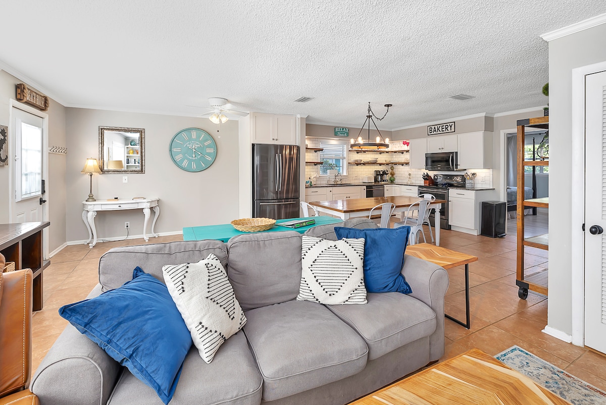 נוף מהסלון לכיוון המטבח, קווין מושכת ספה.