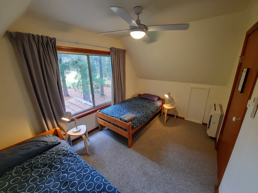 The second bedroom includes 2 single beds fitted with electric blankets, a wall-mounted reverse cycle air conditioner and ceiling fan