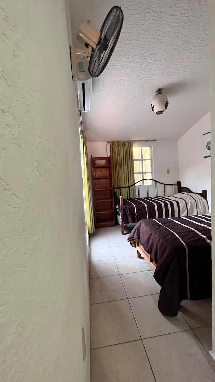 Habitación principal con minisplit, ventilador, baño completo dentro de la habitación.