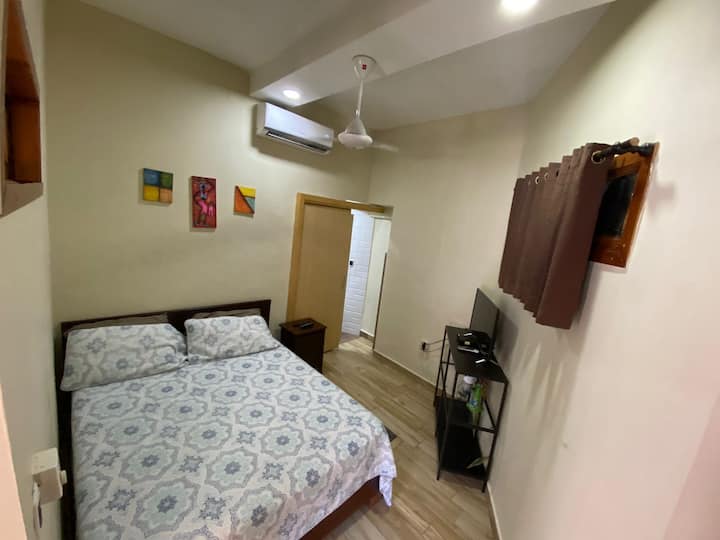 غرفة نوم، A&C، مروحة سقف، تلفزيون وباب حمام.