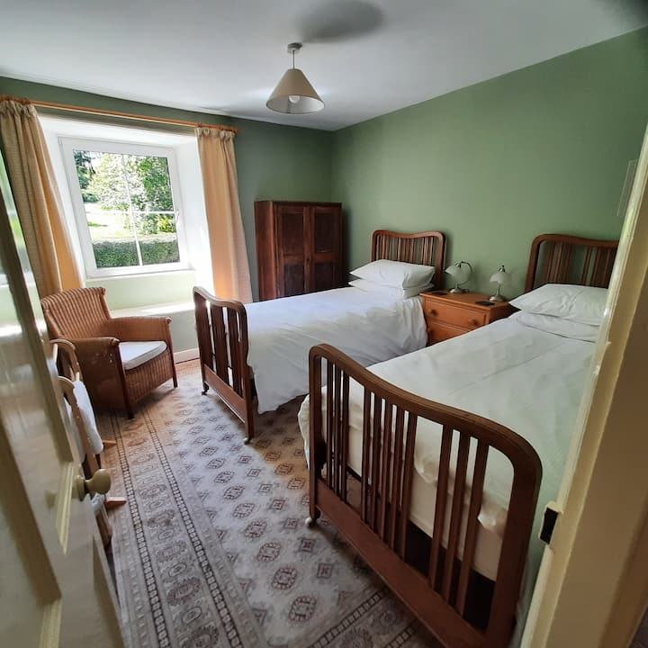 Spavaća soba 4 ima vrlo miran osjećaj i pogled na stražnji vrt na štand s drvećem.