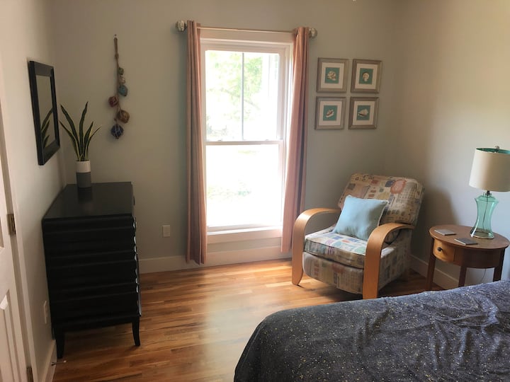 Bedroom 1 with queen bed and comfy chair.