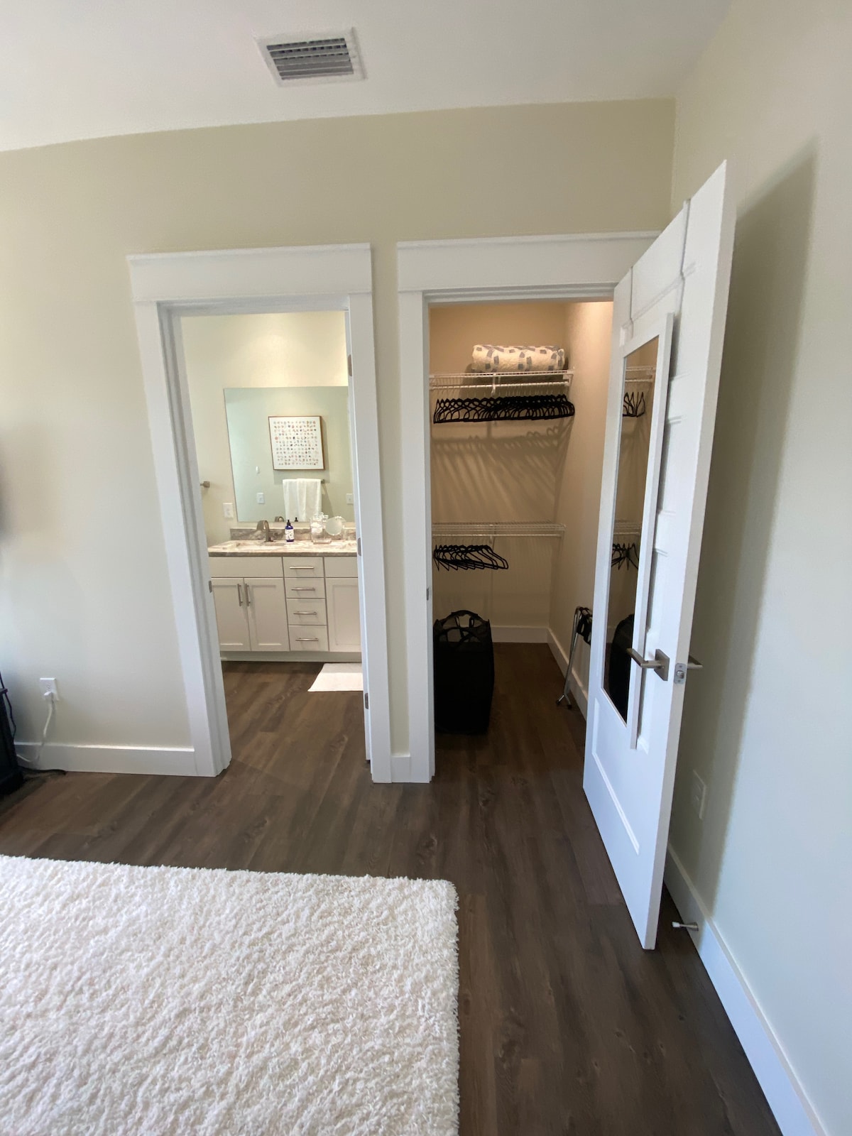 الباب على اليسار هو الحمام الكامل من غرفة النوم الكبيرة في الطابق العلوي والباب على اليمين هو المشي في الخزانة مع مرآة كاملة الطول ، وسلة الغسيل ، ورف الأمتعة ، والشماعات