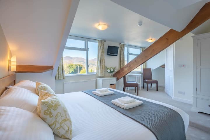 Kamer 8, een super kingsize kamer met twee eenpersoonsbedden of een eigen badkamer met een prachtig uitzicht vanuit twee grote ramen over de St John 's Church en de Newlands Fells. 