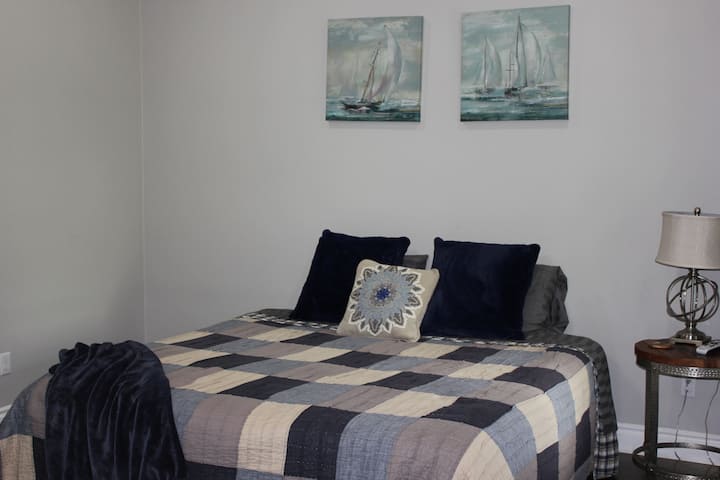 סוויטה 2 של Bunkhouse 1 הקרובה לאגם.  מיטת קינג סייז ראשונה. כריות ושמיכות נוספות בחדר הארונות.  חדר רחצה פרטי עם מים חמים ללא הגבלה ובקרות מיזוג אוויר בודדות.