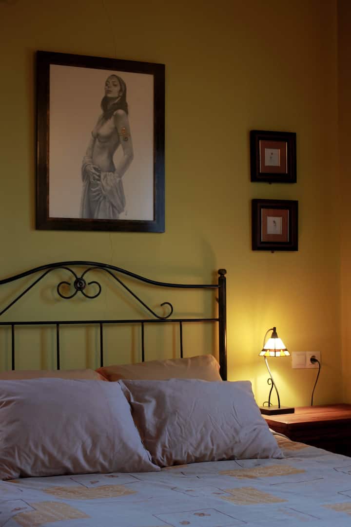 מיטה זוגית בראש חדר השינה הראשי עם ציורים של הצייר מקסימו אלאז. כל הציורים בבית הם יצירות ייחודיות של אמנים אסטוריאנים מקומיים. 